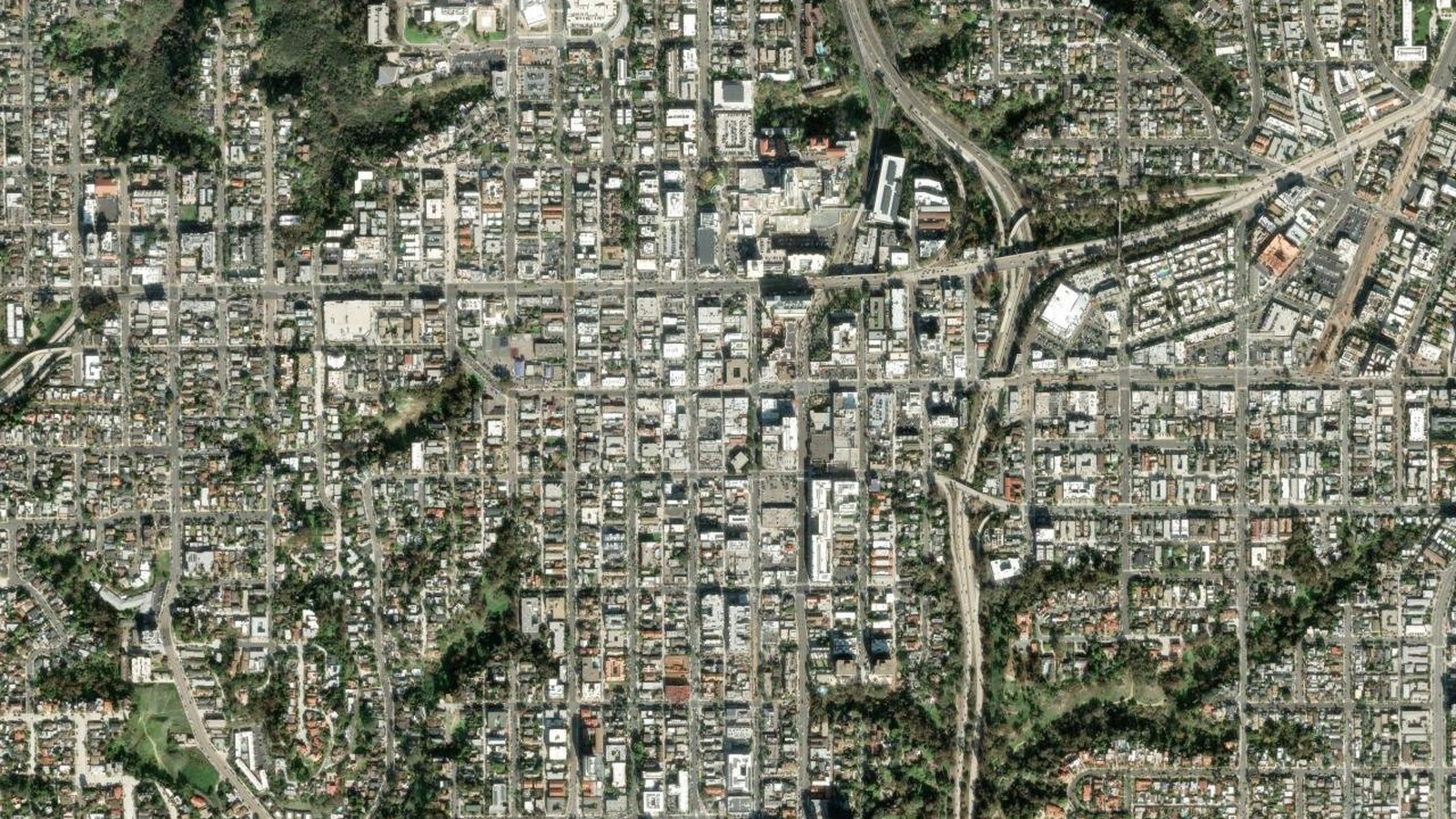 Wide-area satellite view of the Hillcrest neighborhood of San Diego showing the surrounding street grid, Balboa Park to the south, and the canyon corridors that frame the district